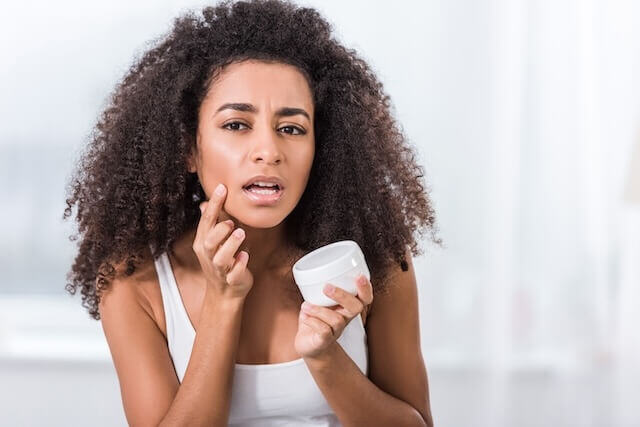 Woman Applying Topical Acne Treatment